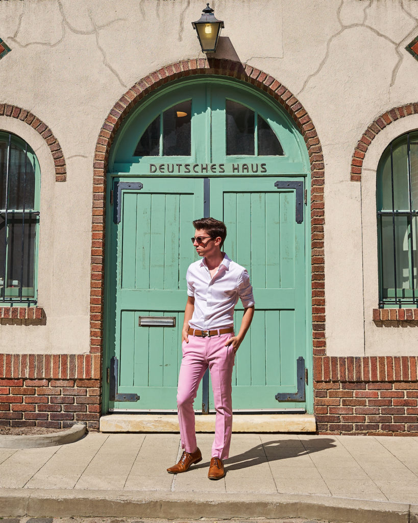 Eitan Bernath stands in front of a green door in purple pants in NYC.