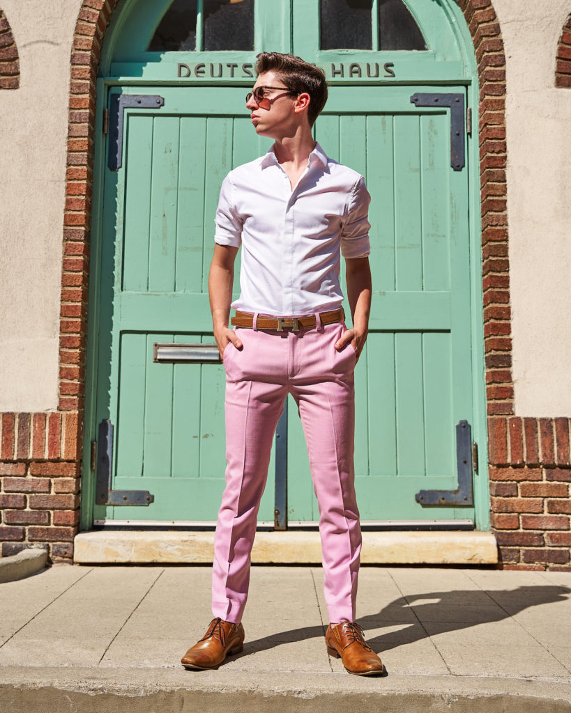 Street Style star Eitan Bernath wears pastel menswear in front of a green door in New York.