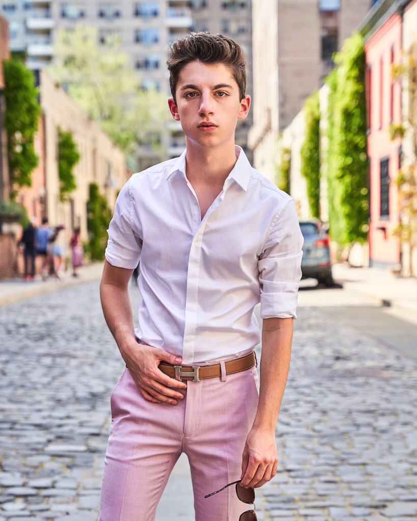 Eitan Bernath wears lilac pastel menswear pants with white button down shirt and hermes belt on the streets of NYC. 