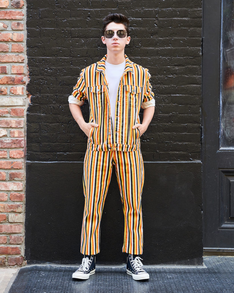 Eitan wears matching two-piece denim set with Converse sneakers.