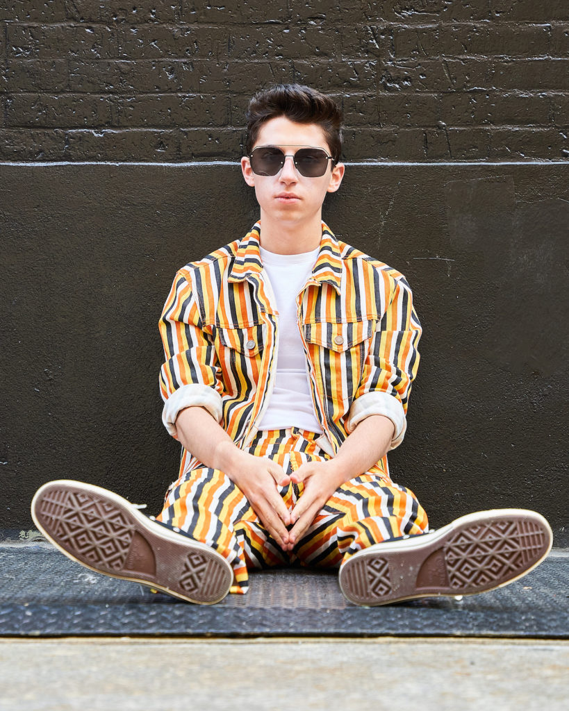 Eitan sits in two-piece striped denim set in NYC.